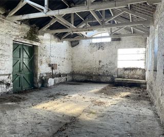 Inside a barn plot that has white wooden beams