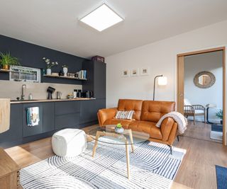 garden room annexe with kitchenette, living room area and pocket door open leading into another room