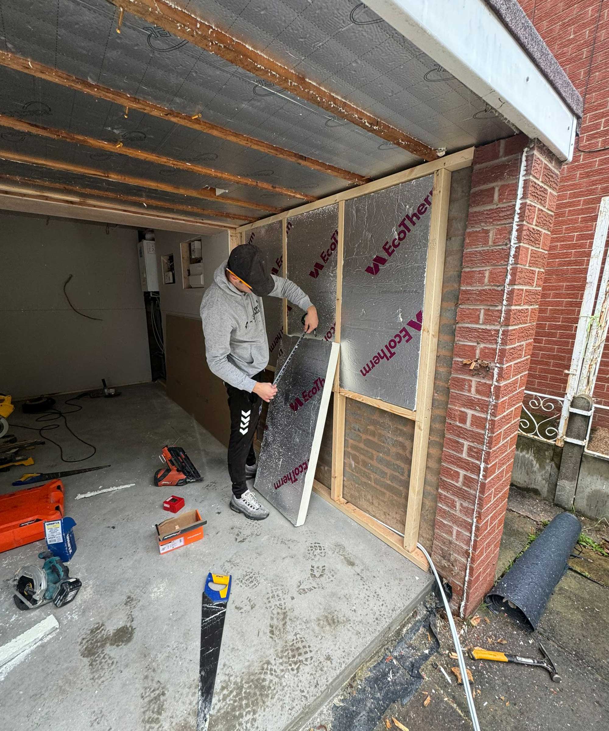 man fitting Kingspan rigid board insulation into garage conversion
