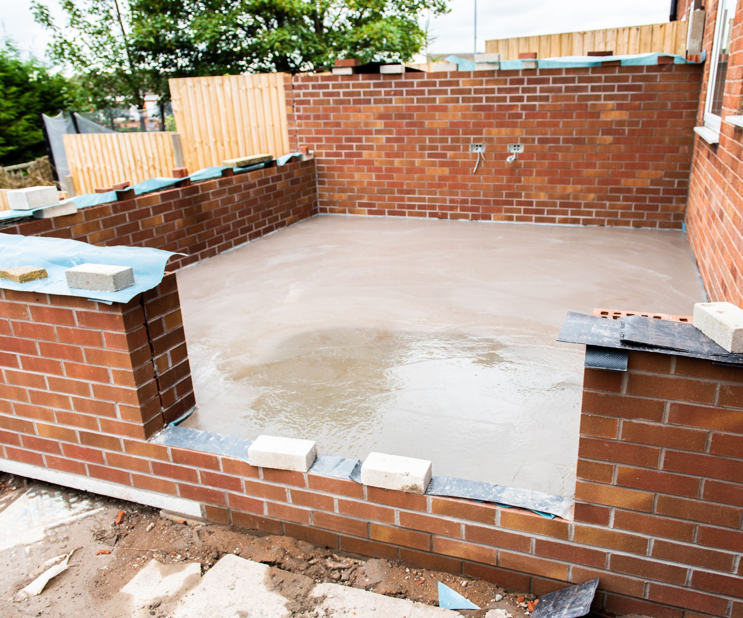 Red brick half walls with a concrete internal floor