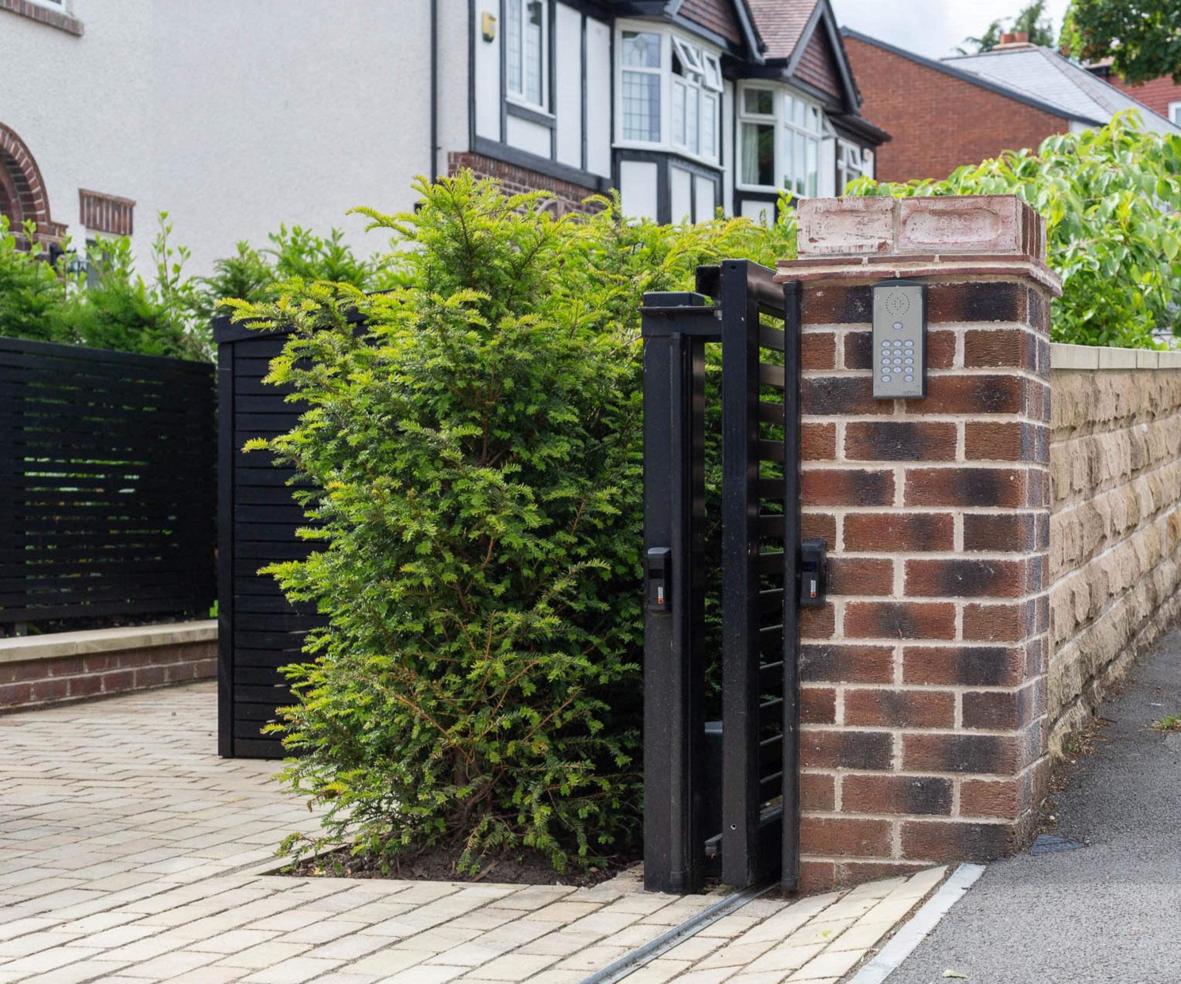 front garden wall with brick pillars matching details on house pale brick paving