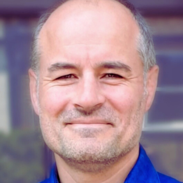 male with short grey hair and stubble