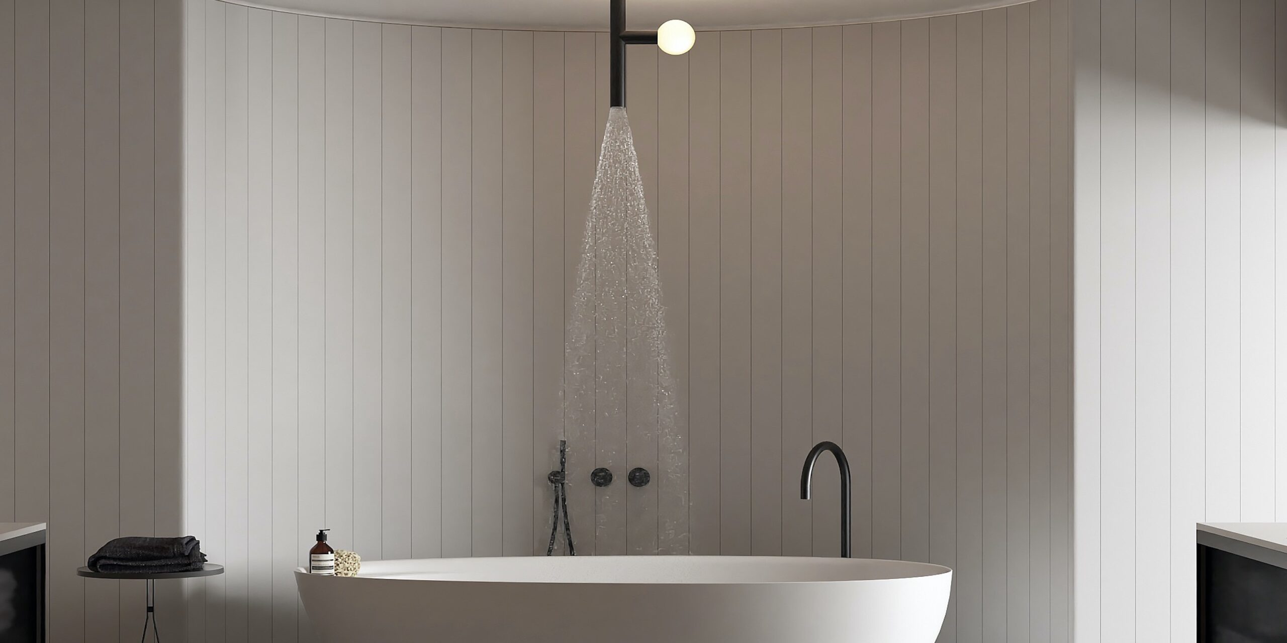 Freestanding bath in a curved alcove with overhead light and shower