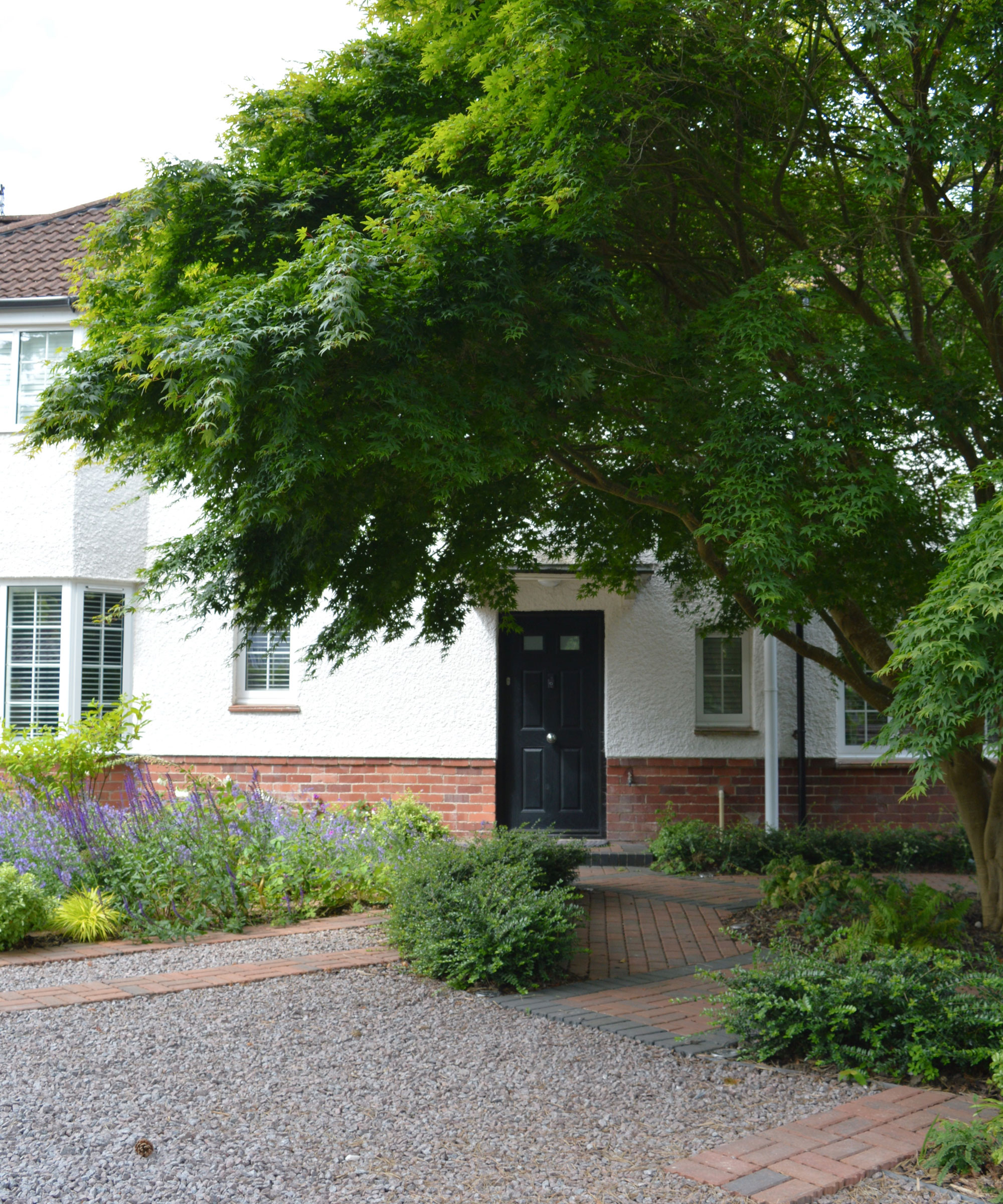 gravel driveway with tree and planting