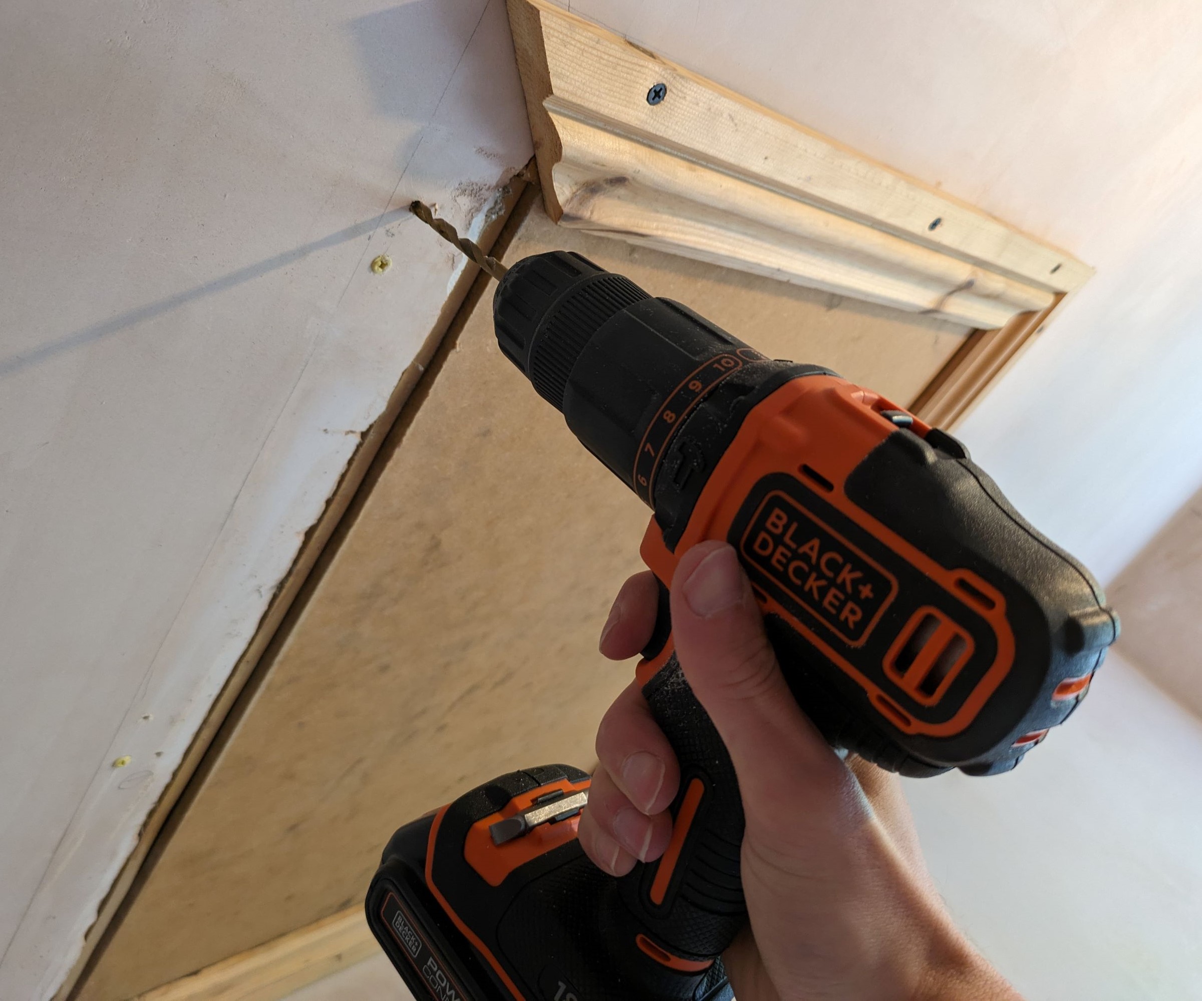 Black & Decker drill drilling into a plaster ceiling