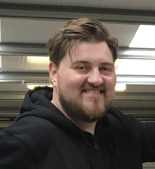 Expert headshot of a bearded man in a black hooded sweatshirt