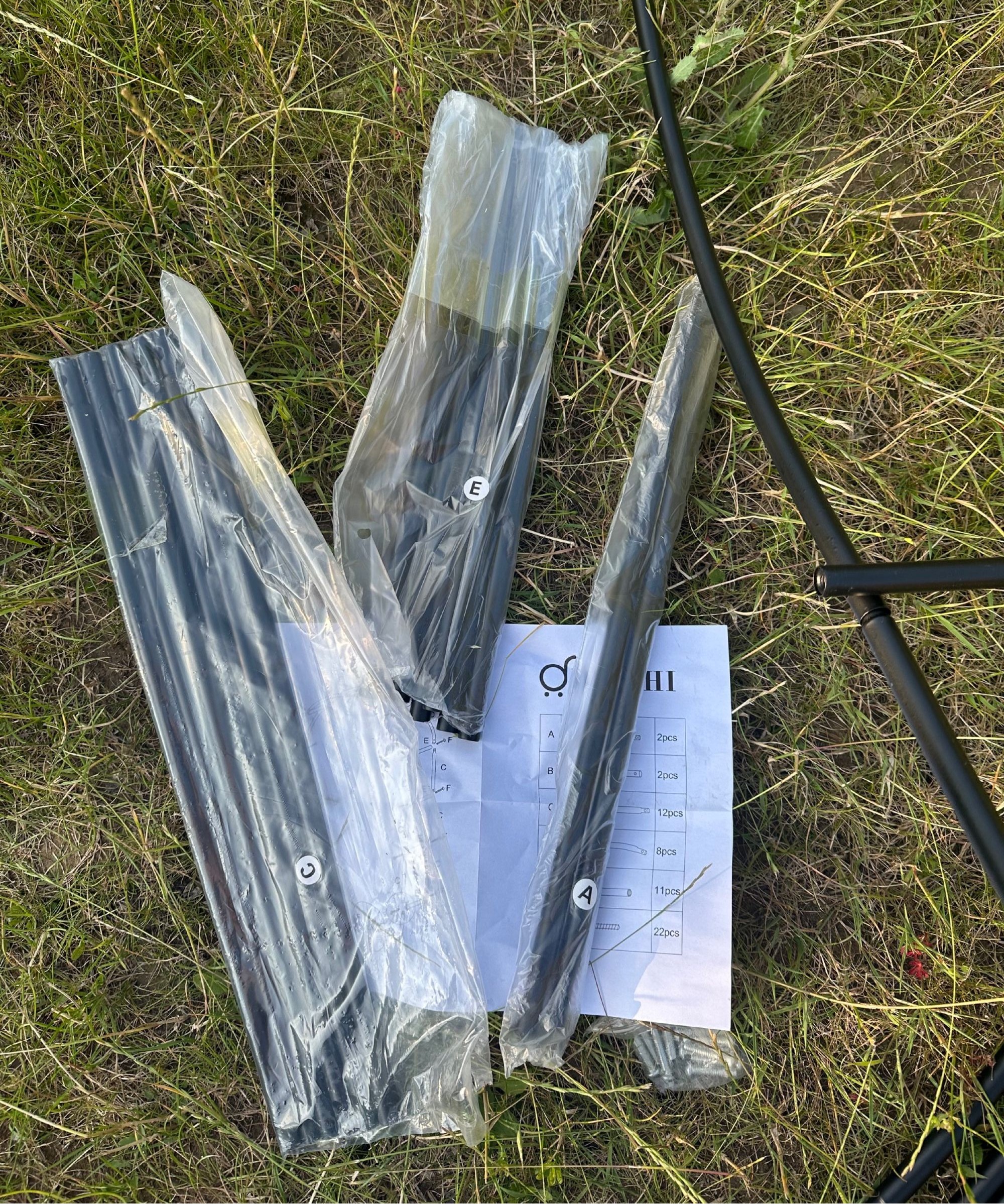 A collection of metal rods in plastic bags for assembling the garden arch