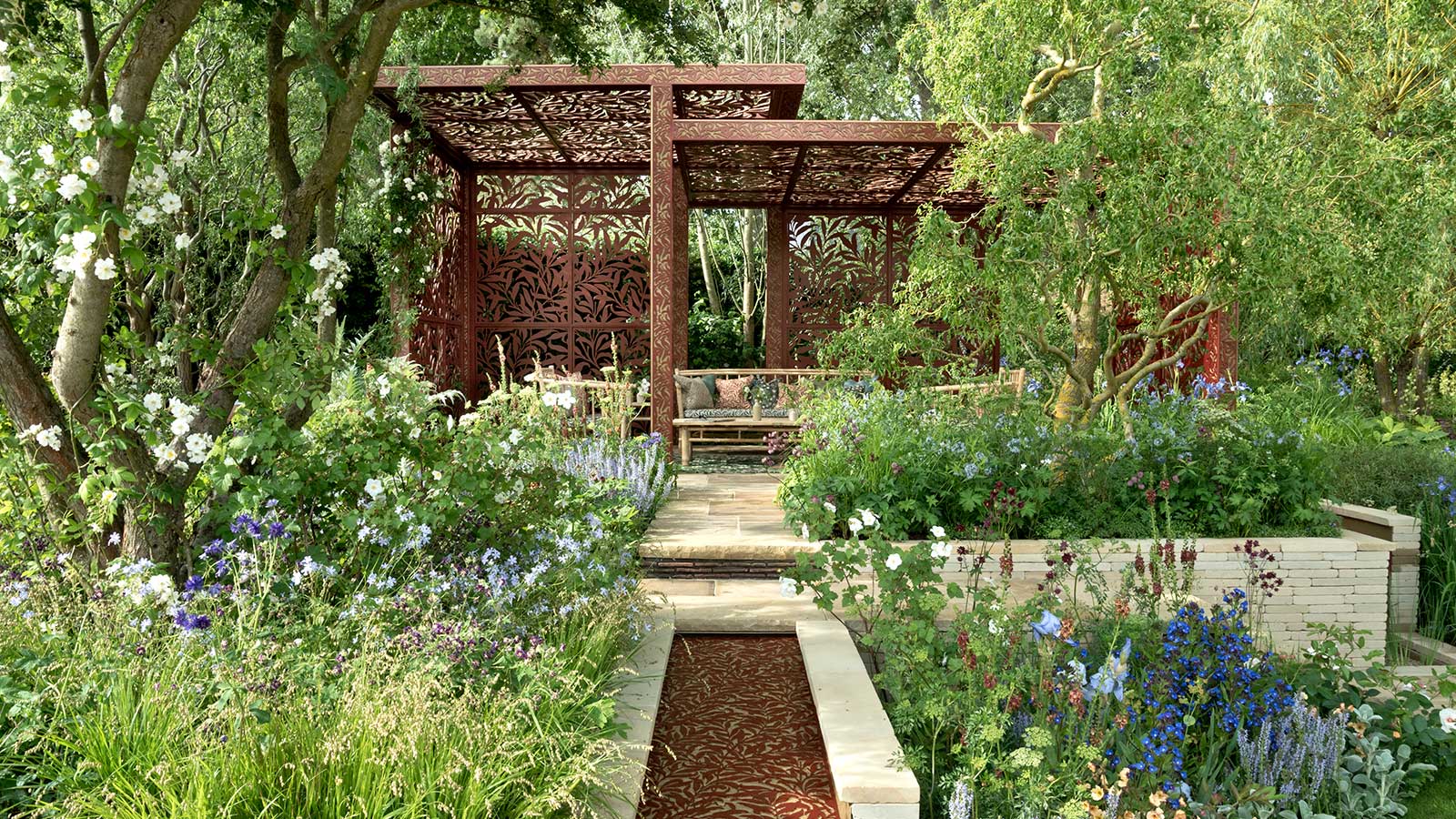 raised patio with a large pergola overhead in a garden at the Chelsea Flower Show