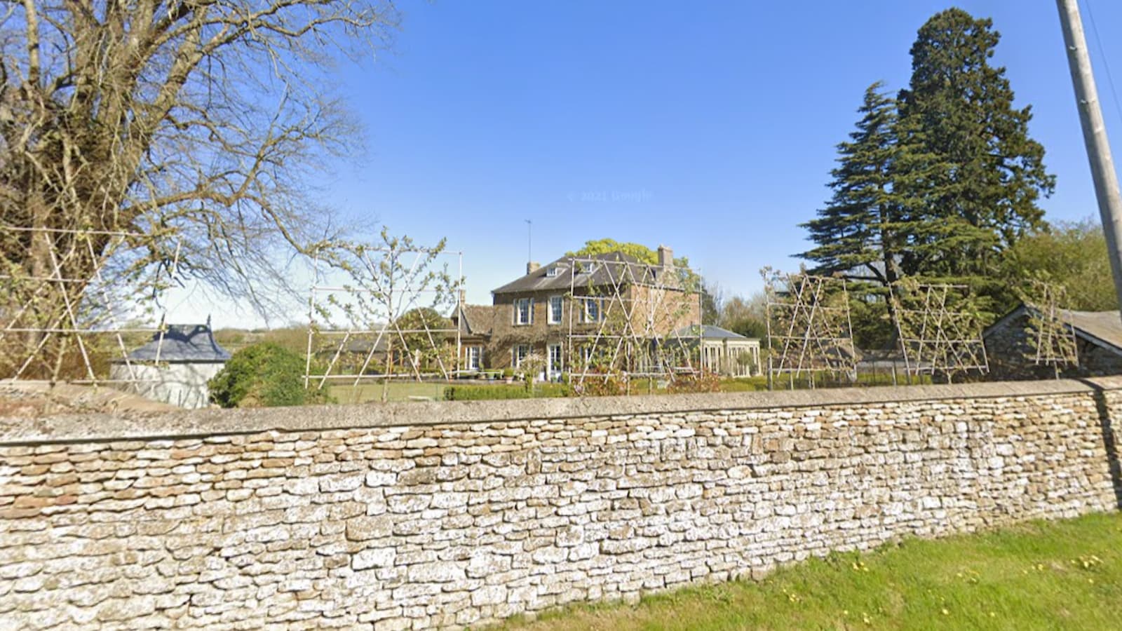 An image of a Christian Horner and Geri Halliwell's brick house with stone wall around the perimeter