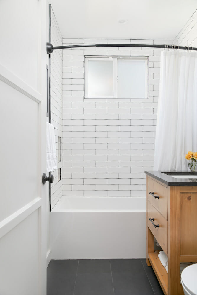 Image of a renovated bathroom tub with white subway tile walls