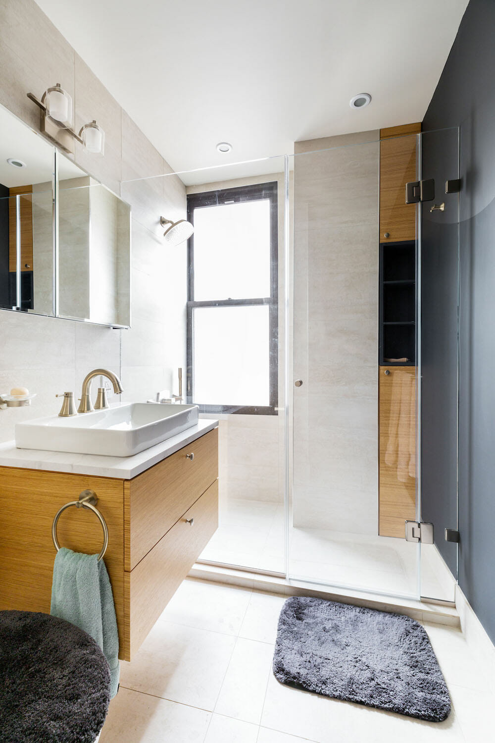 wood veneer custom cabinets with glass shower door and white vessel sink on floating cabinet after renovation 