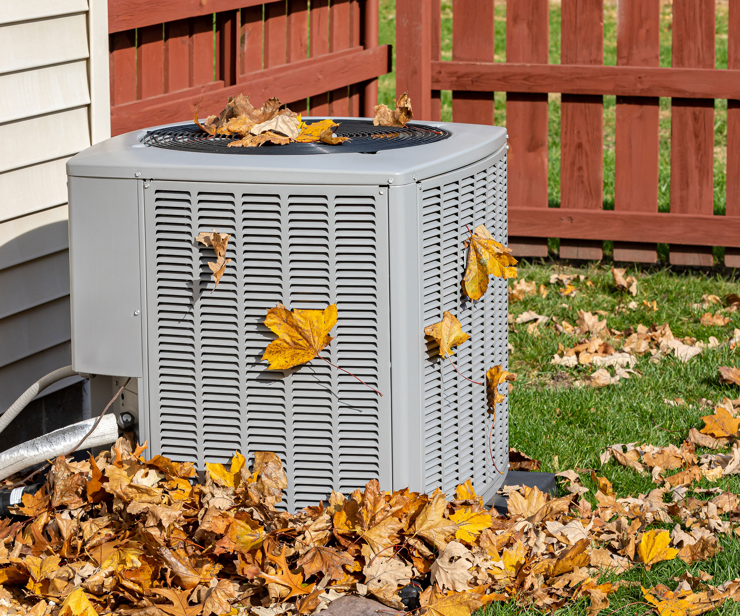 heat pump surrounded by fallen leaves