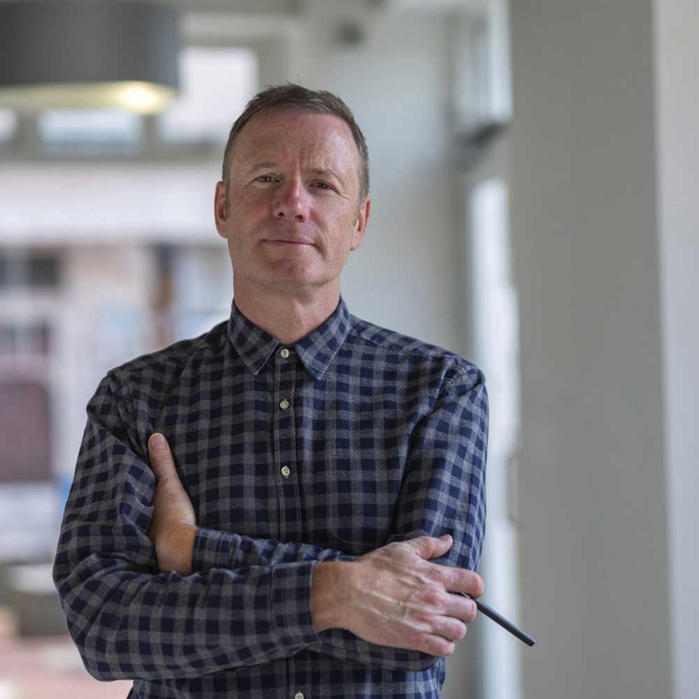 photo of Nick Duggan from The Radiator Centre, a man holding a pen and wearing a checked blue shirt