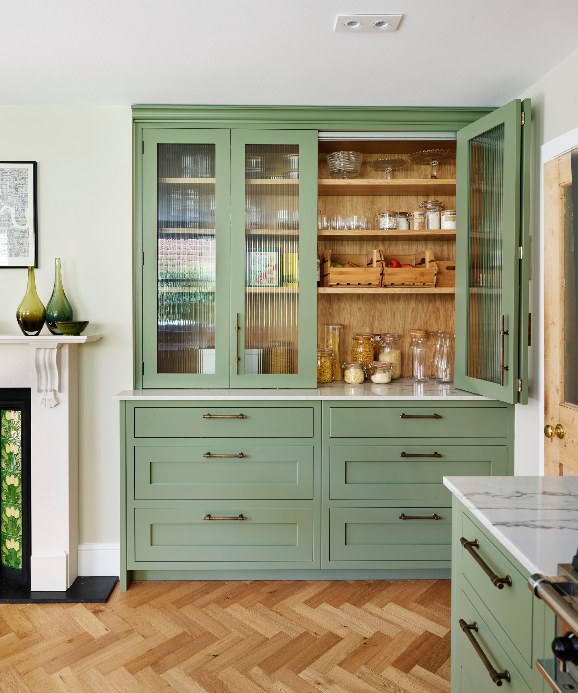 built in kitchen cabinet in sage green being used as a larder