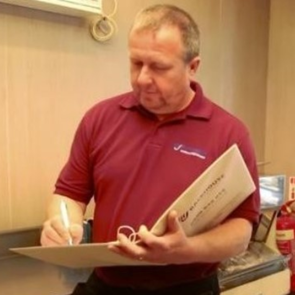 Darren Backhouse signing paperwork in a folder