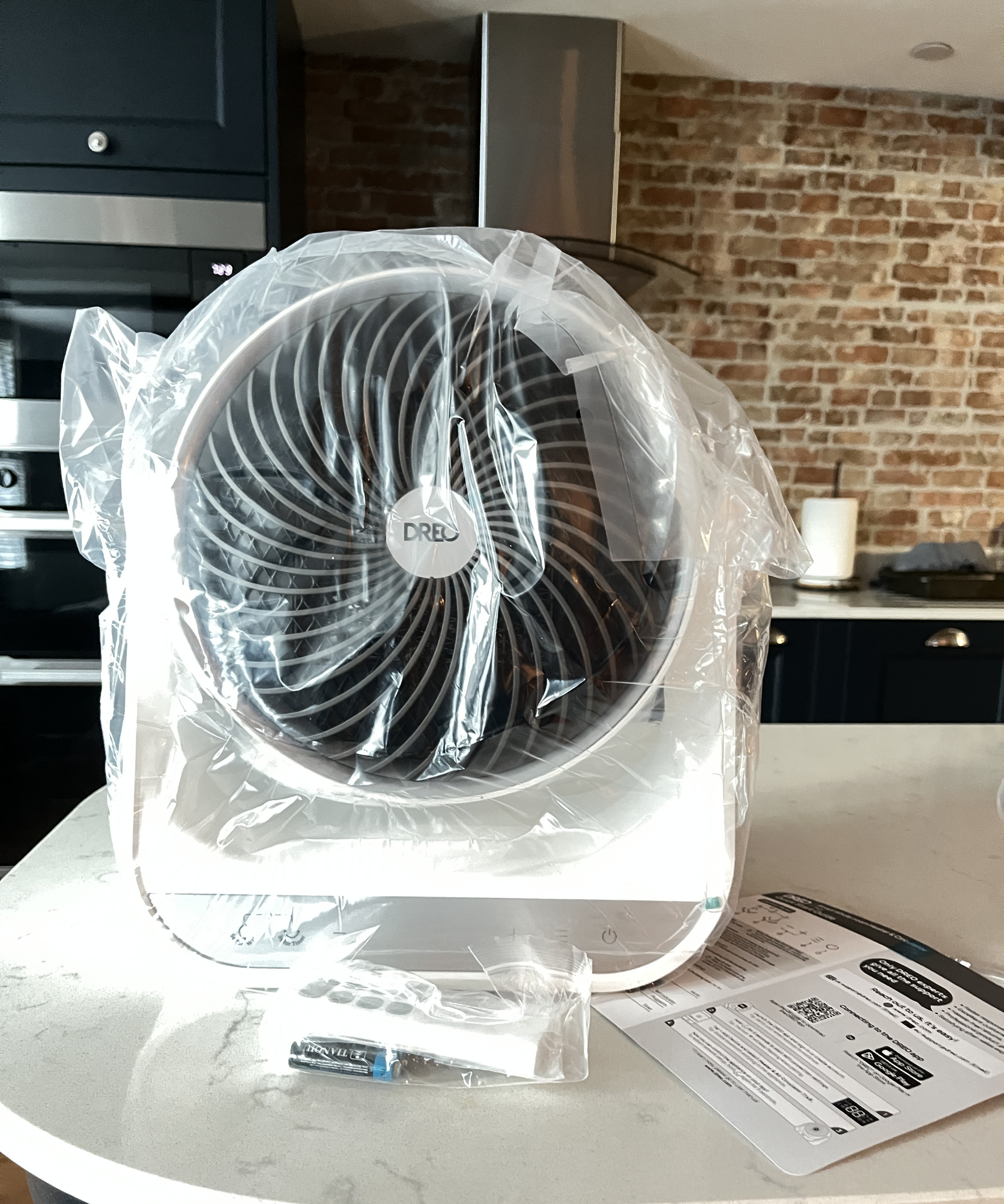 heater with clear cellophane packaging still on, instruction manual and remote control