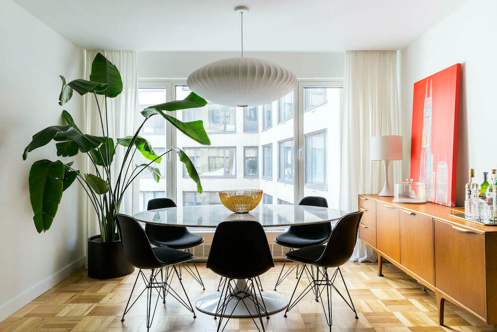 Dining area with glass table in front of large window