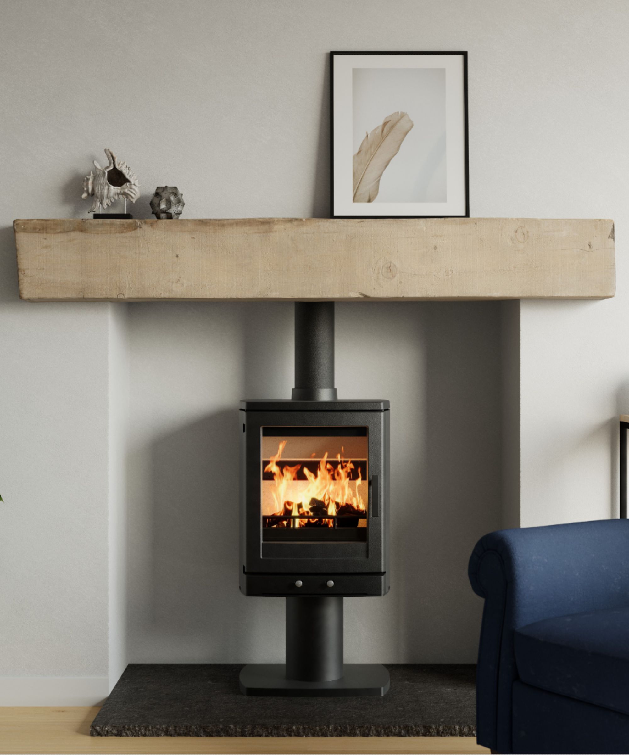 A contemporary fireplace featuring a cylindrical black log burner on a pedestal base, framed by a thick oak beam mantel. Above, a simple framed artwork of a feather leans against the wall, creating a natural, understated look in the room.