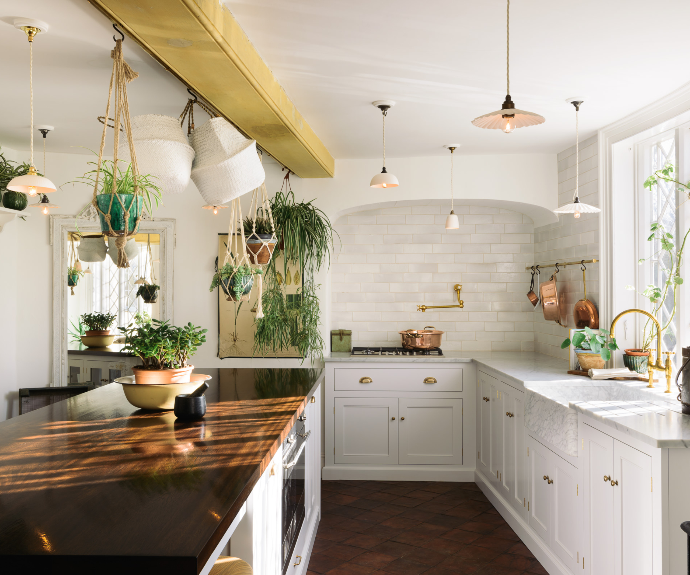 kitchen with white units, dark wooden floor, yellow beam on ceiling and lots of hanging pendant lights