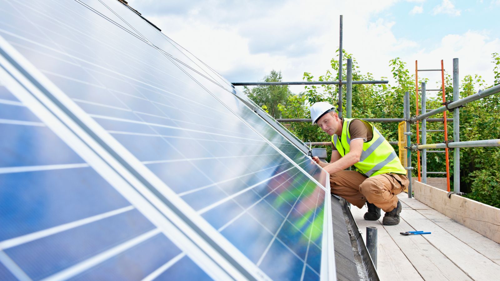 man working on solar panels on roof