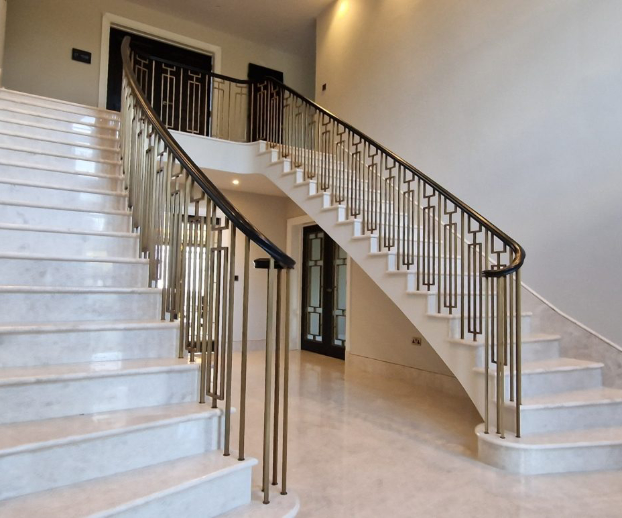 split staircase in entrance hall with tiled stairs, metal handrail and spindles