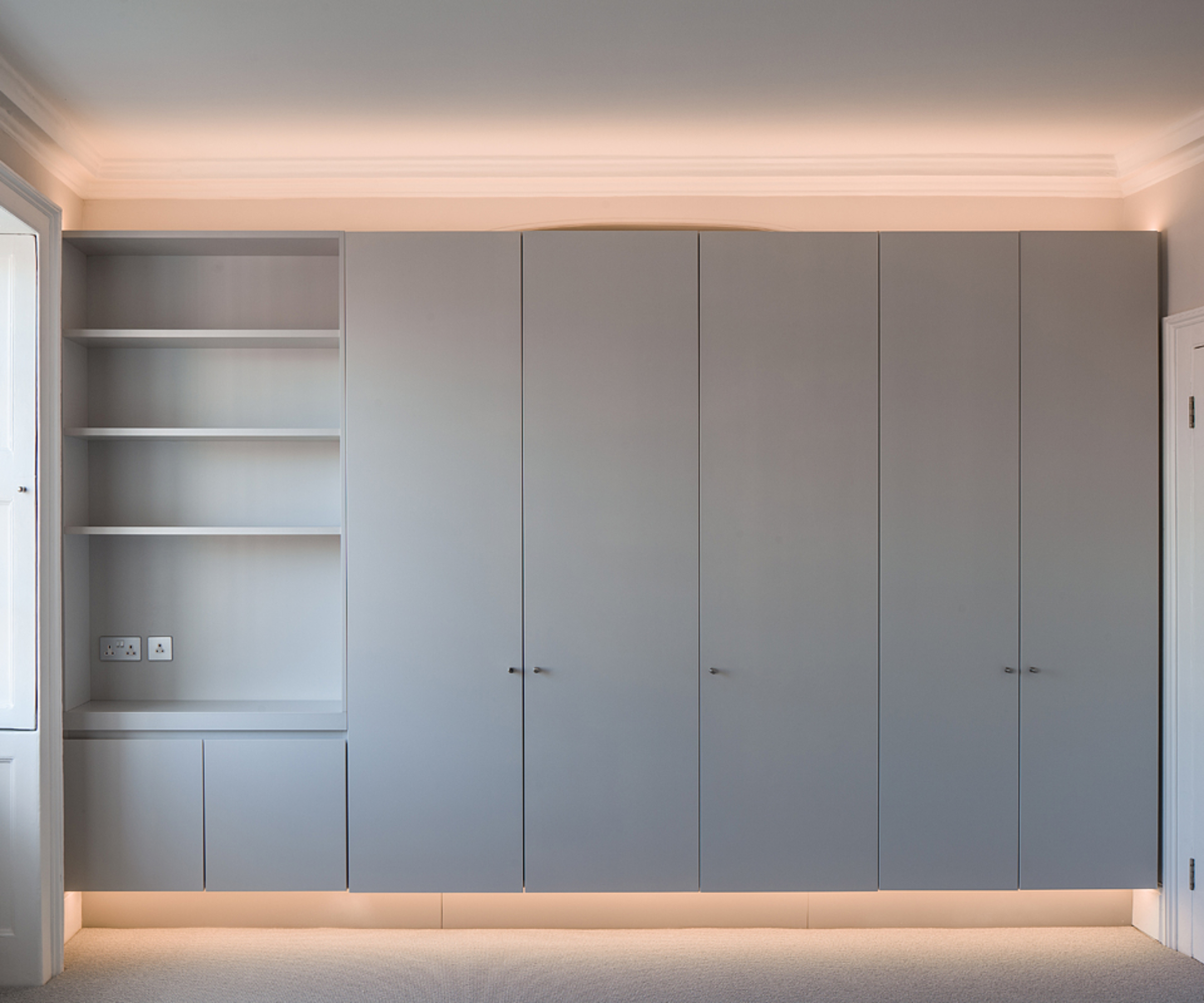pale grey built in storage with concealed lighting above and below