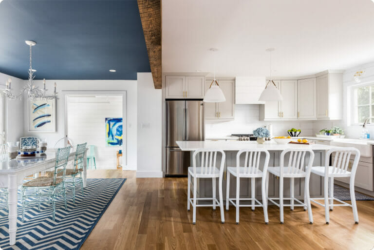 Open concept kitchen with white kitchen island and barstool seating renovated by a Sweeten general contractor