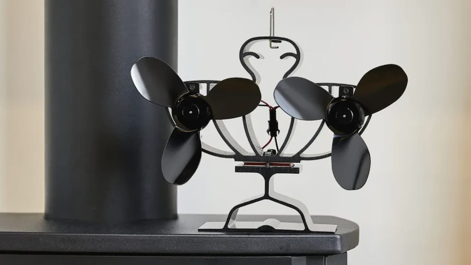A double-sided stove fan on top of a black woodburner