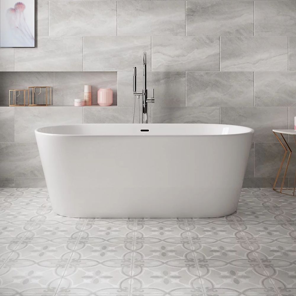 A modern bathroom featuring grey stone-effect wall tiles and patterned ceramic floor tiles.
