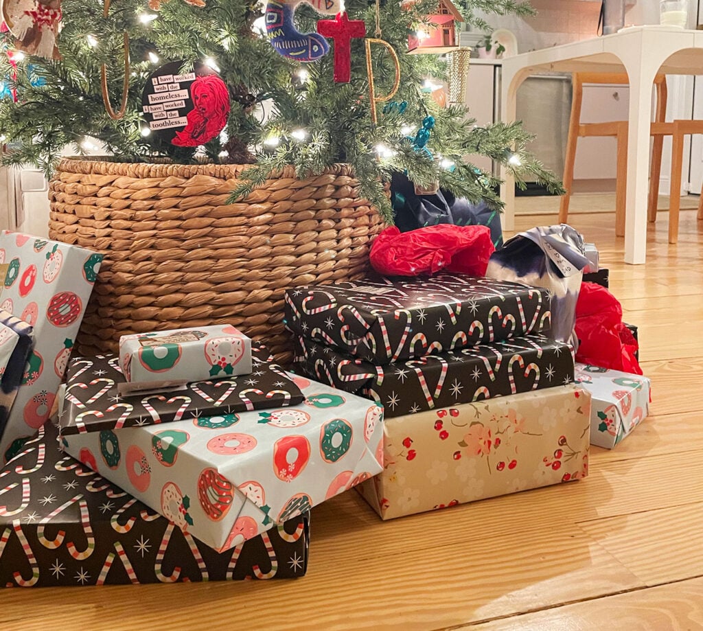 Close Up Of Christmas Presents Under A Tree With Woven Tree Skirt