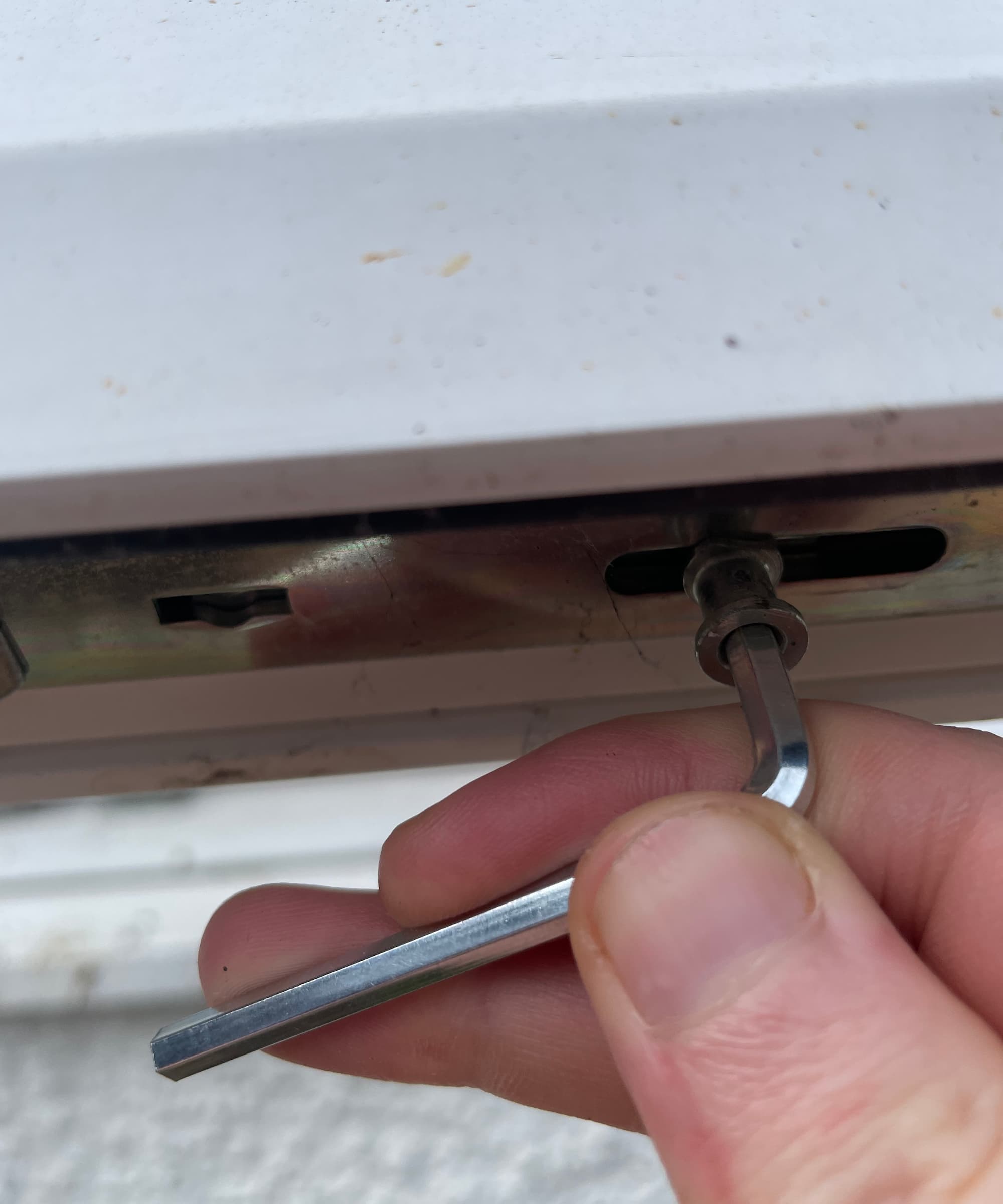 The inside catch of a uPVC window being turned with an Alan key