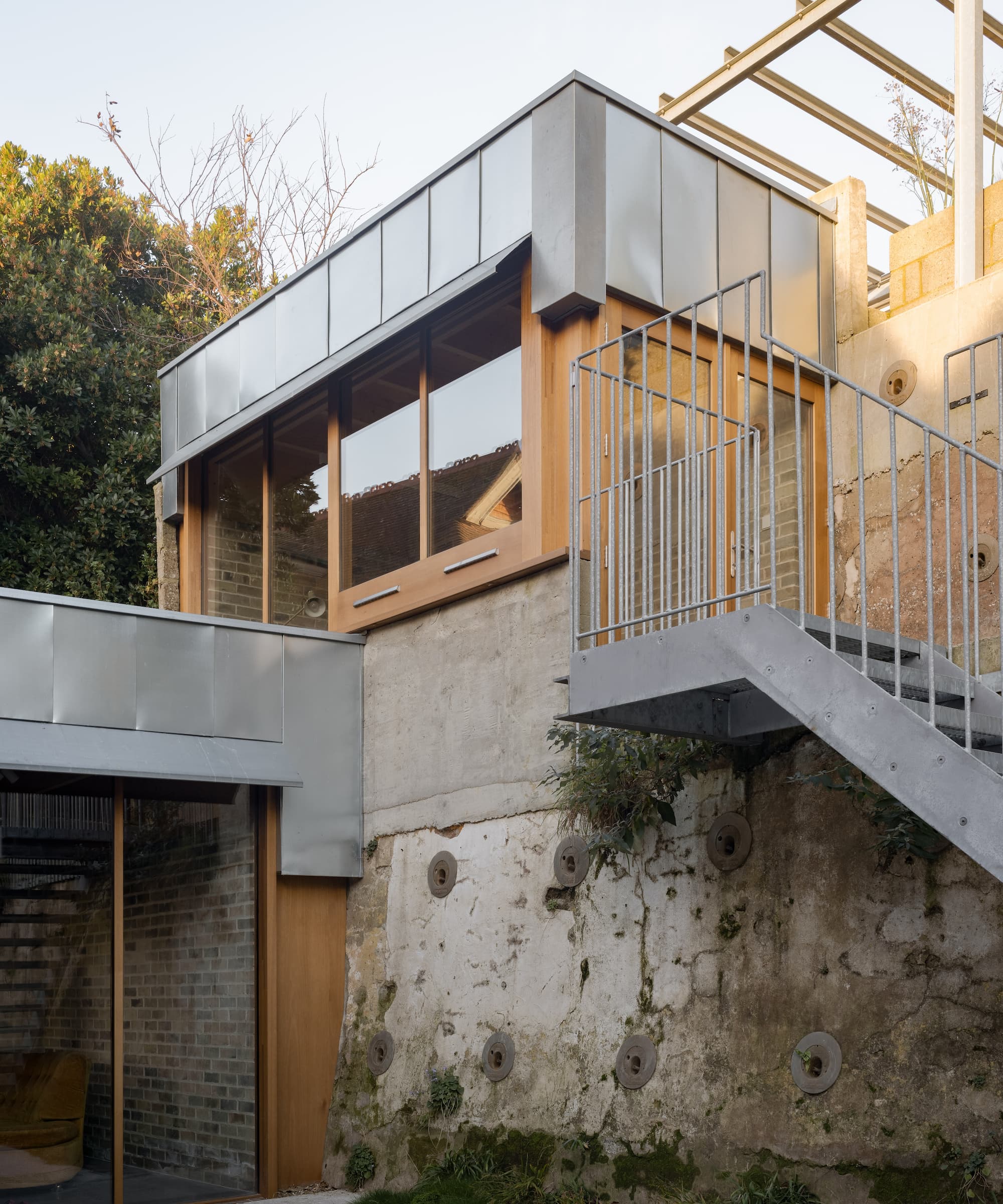 An extension built on a sloped site with a metal staircase