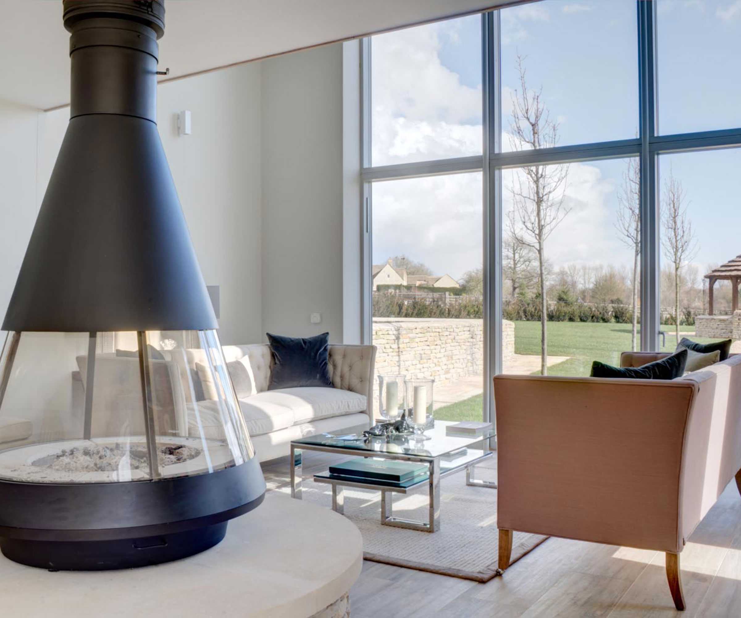 Dutch barn conversion interior with full height glazing and freestanding log burning stove