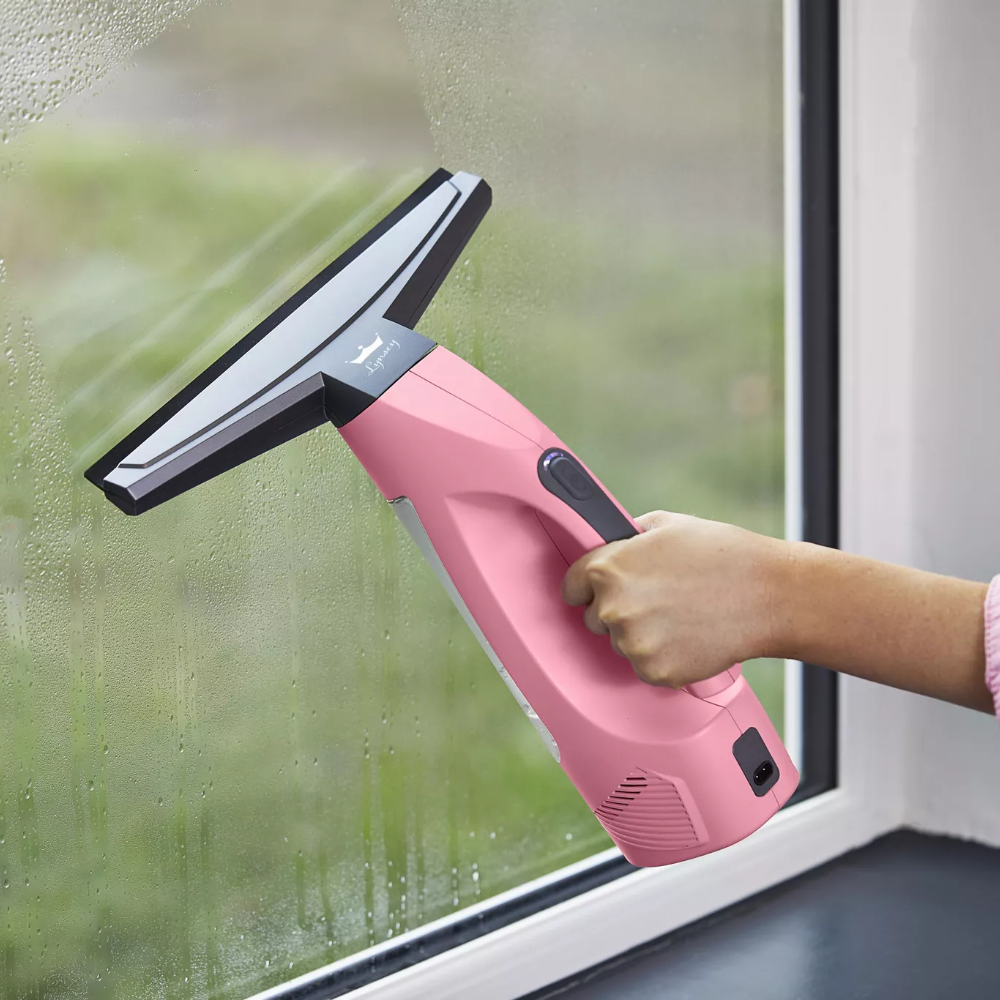 Hand using the Swan x Lynsey SC59010QOC Rechargeable Cordless Window Vac, one of the best window vacs, on a window with condensation