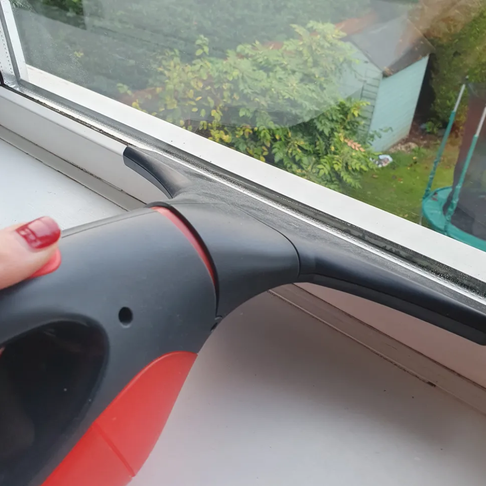 Michelle holding the Vileda Windomatic Power Window Vac on the her window, having just wiped away the condensation shown in the previous image