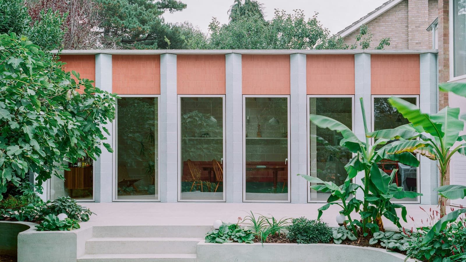 A kitchen extension with blue columns and floor-to-ceiling windows
