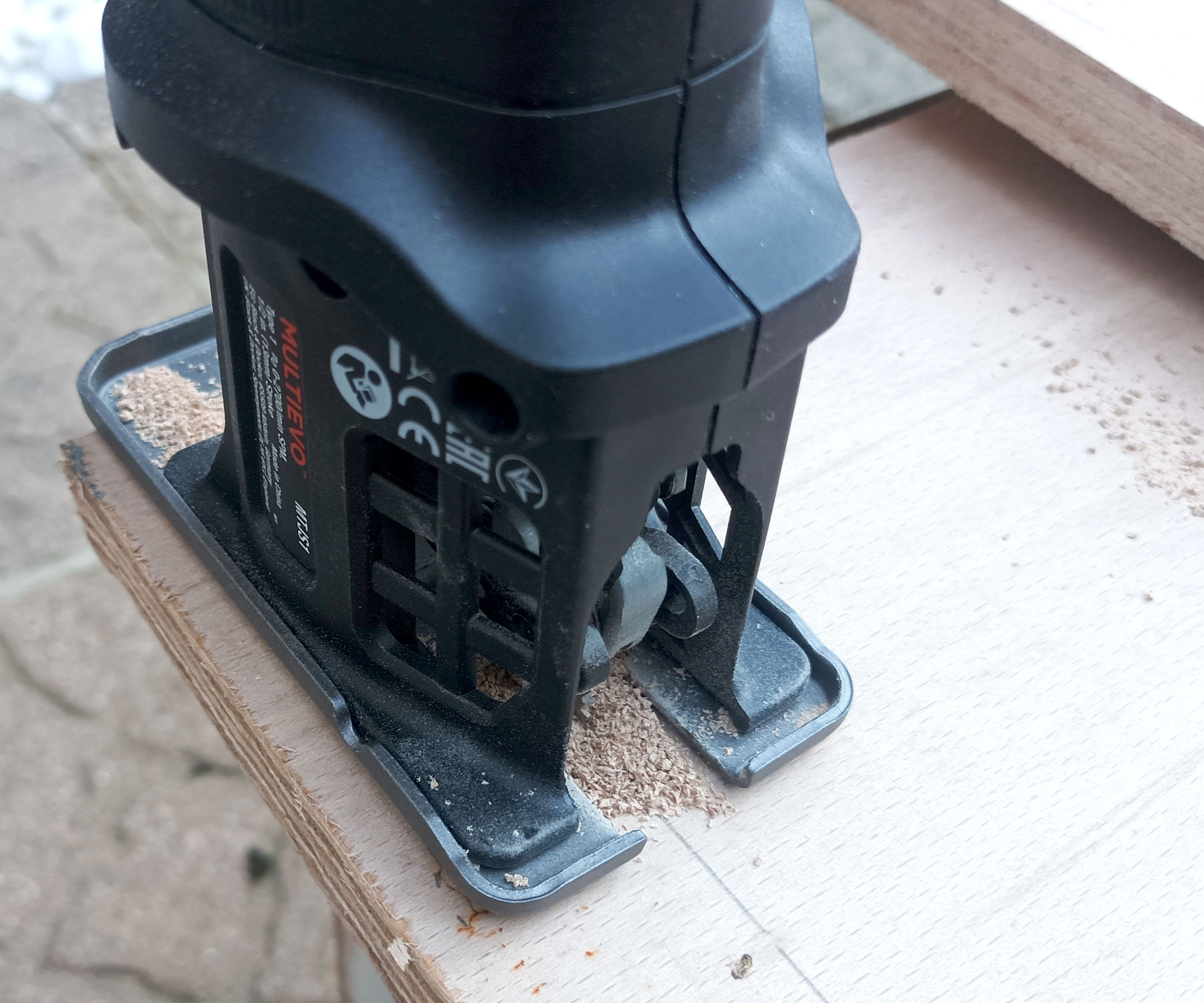 Close up of Jigsaw attachment cutting along a pencil line on plywood