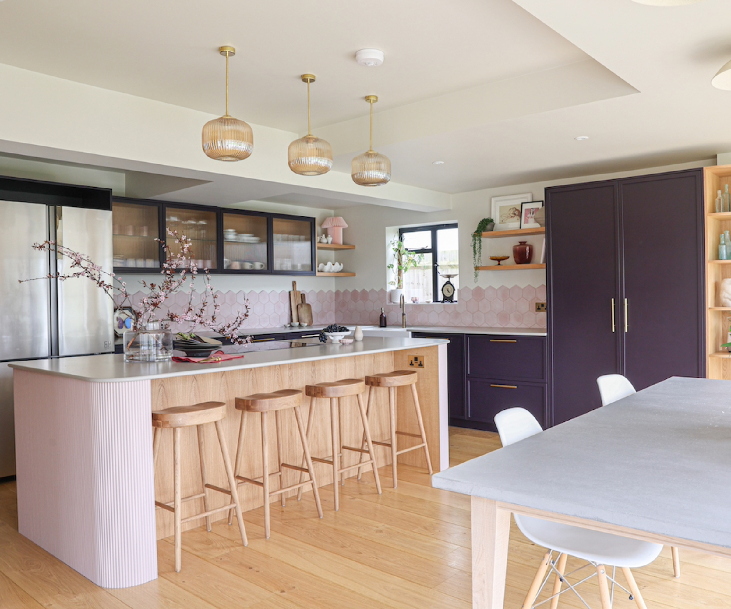 Kitchen with pink and wooden kitchen island and dark blue cabinets