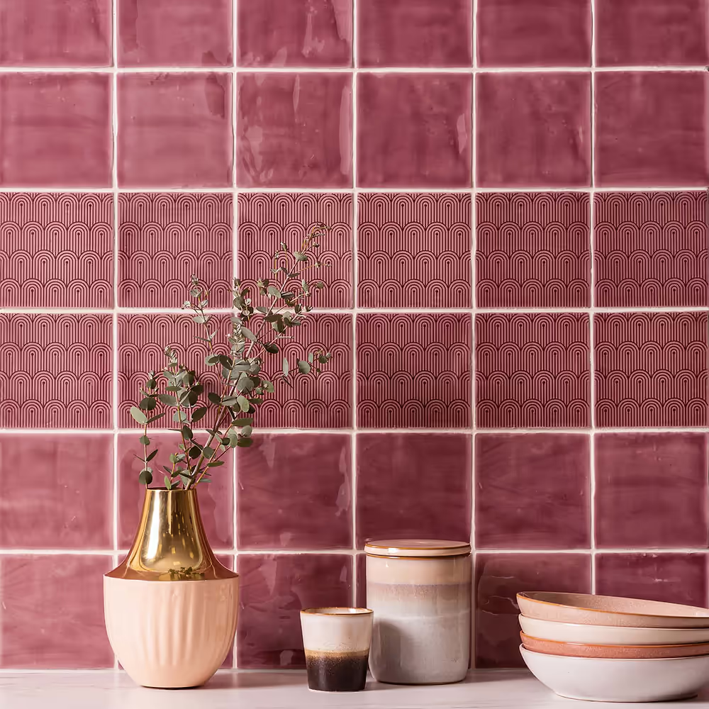 Pink tiles with kitchen accessories in front on the worktop
