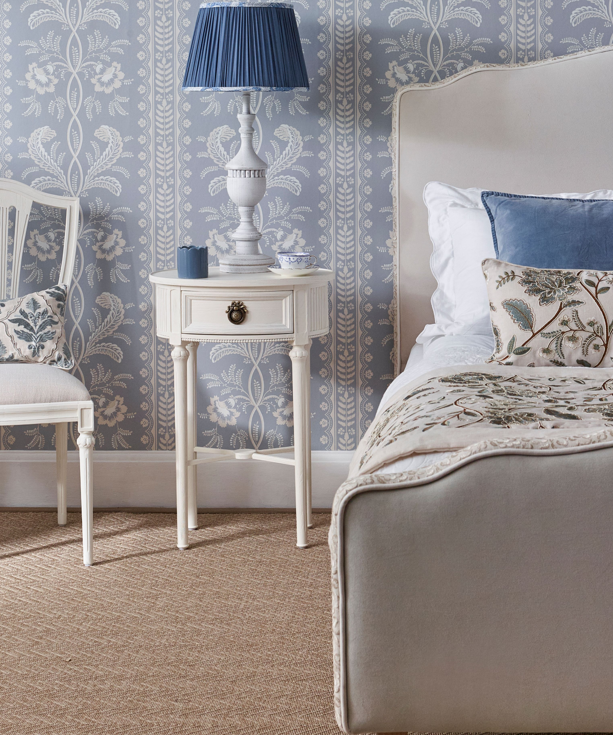 bedroom with off white furniture and blue and white patterned wallpaper