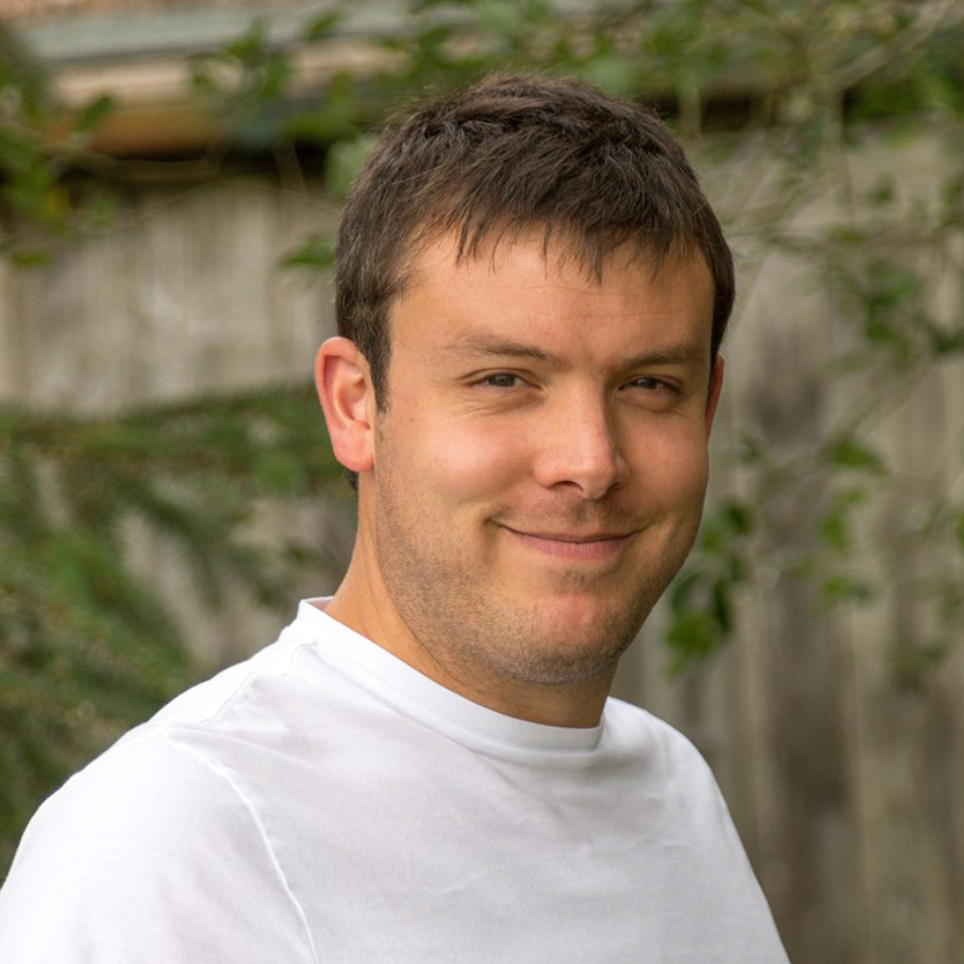 male with short dark hair wearing white t-shirt