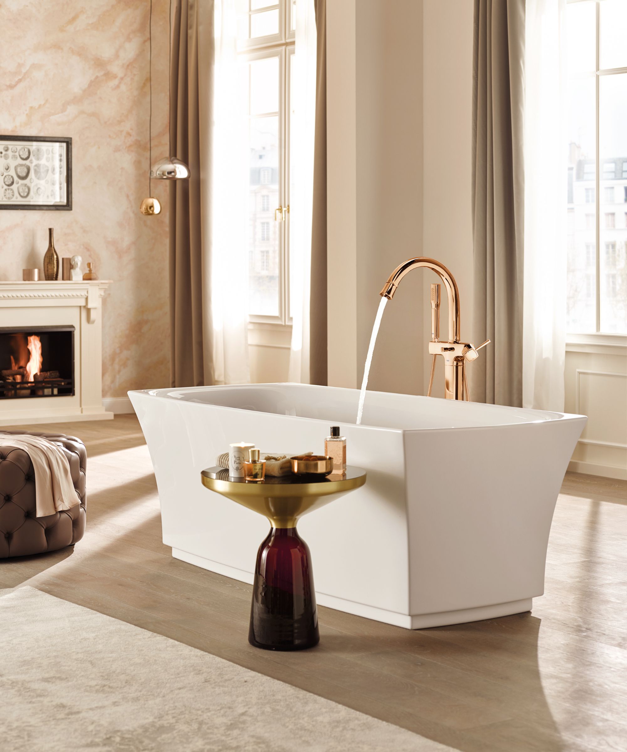 An elegant freestanding bath set in a light-filled room, paired with brass taps, soft neutral textures and a relaxed, hotel-style layout.