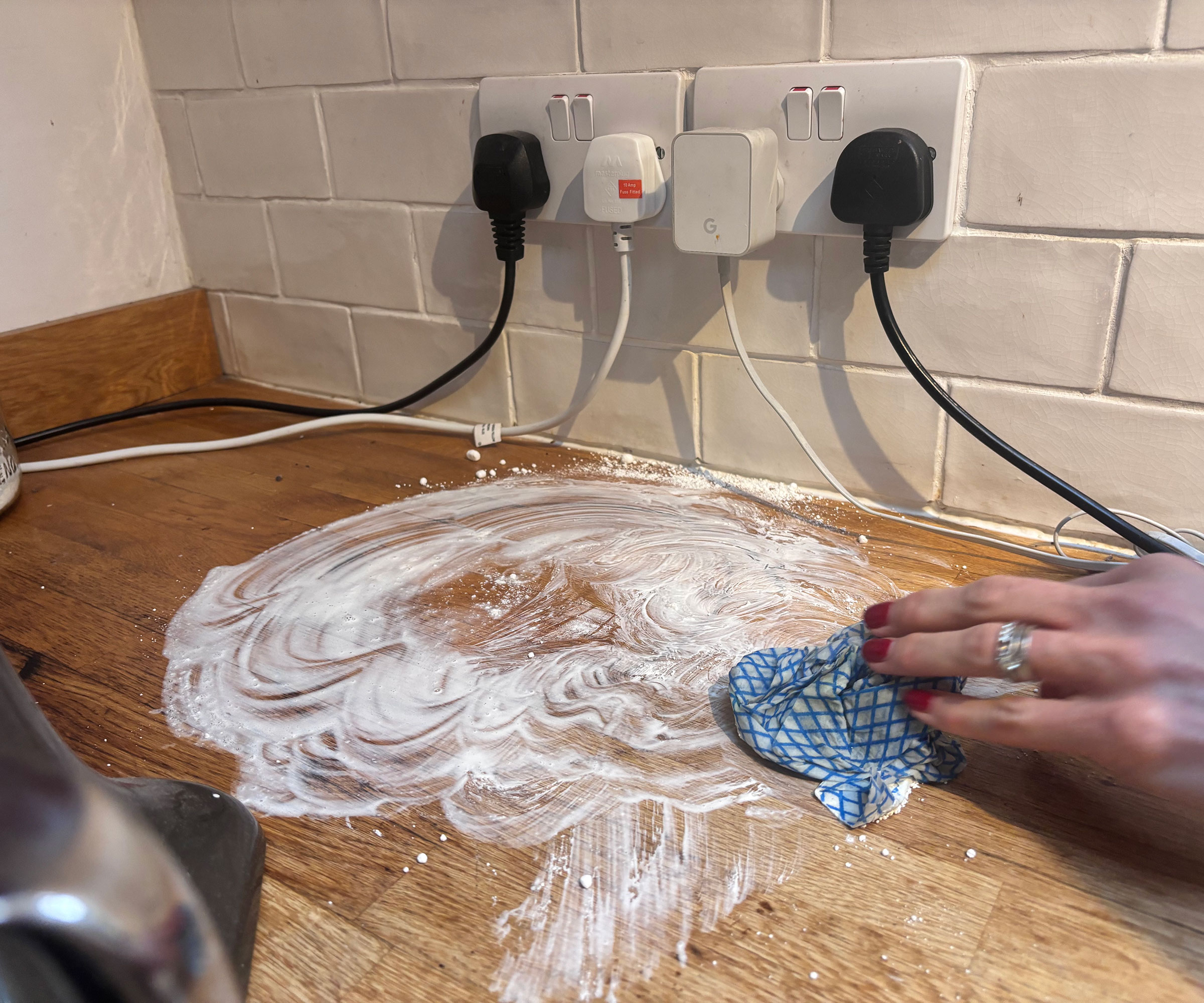 cleaning stains off a wooden worktop with an abrasive cleaner