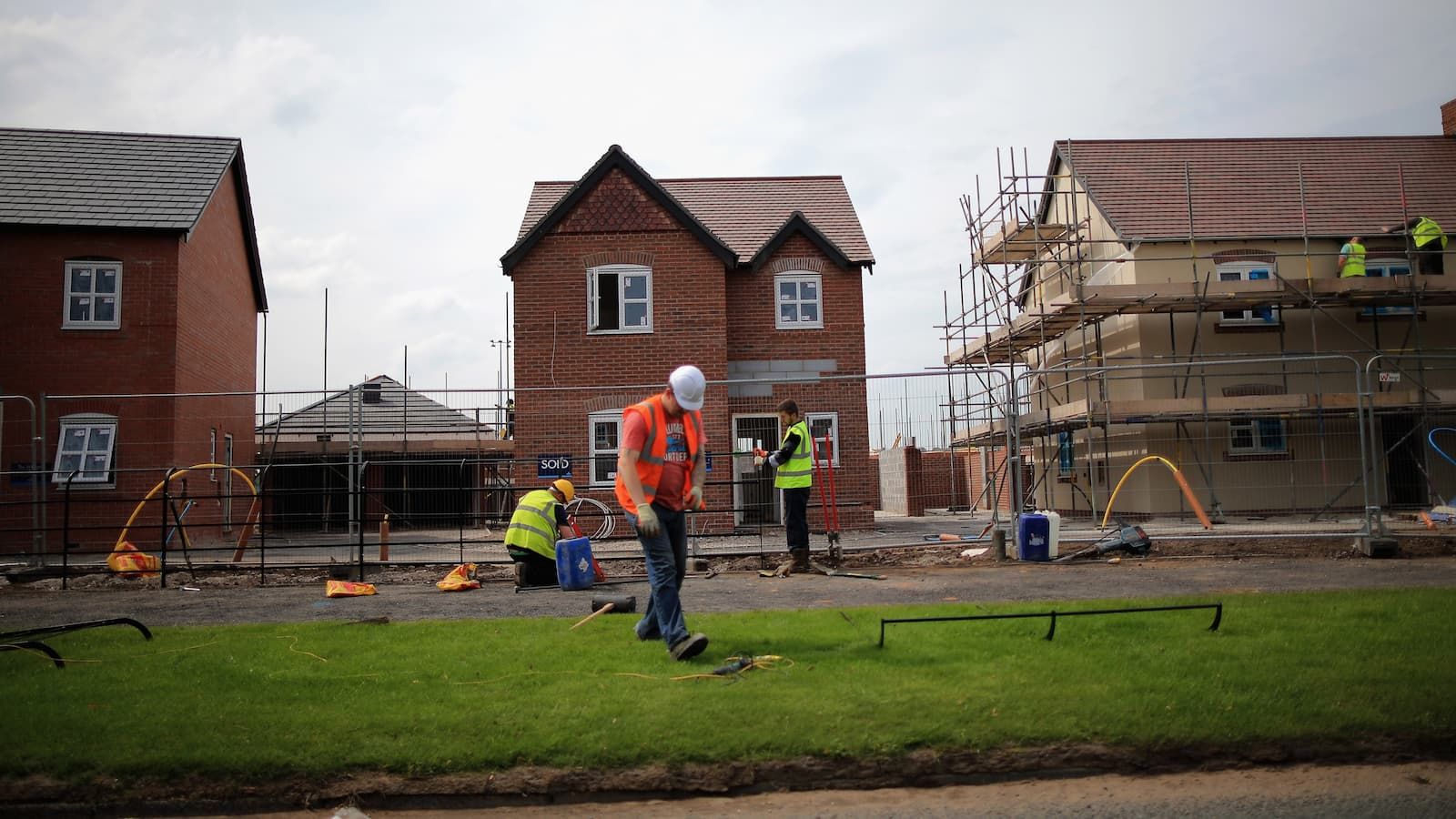 Construction workers build new houses on a housing development on May 20, 2014 in Middlewich, England