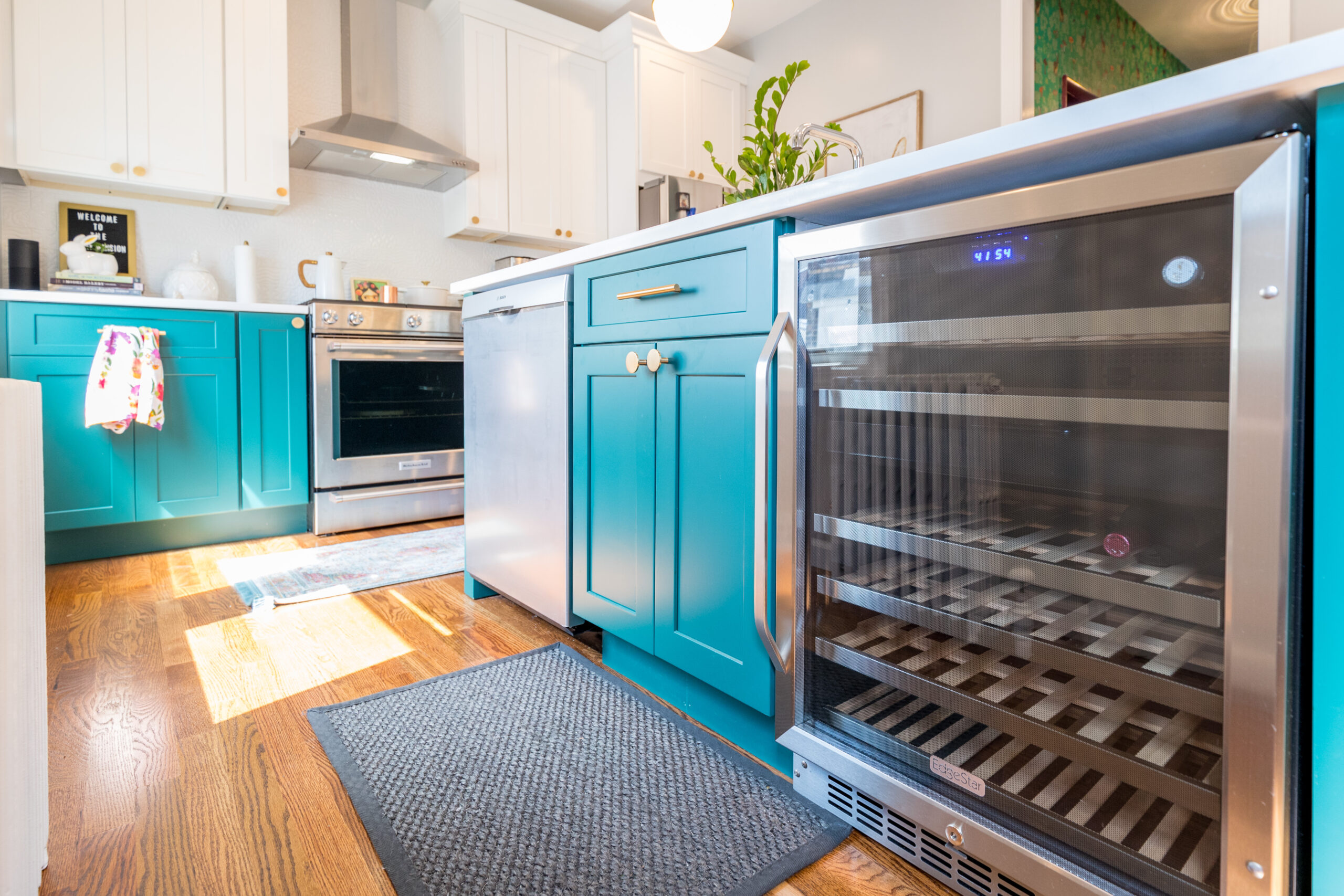 Kitchen with pine green cabinet colors, a beverage fridge, and wooden flooring